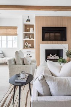 a living room filled with furniture and a fire place in the middle of the room