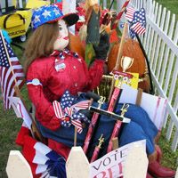 a group of clowns sitting on top of a white picket fence