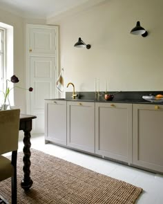 a large kitchen with white cabinets and black counter tops, along with a rug on the floor