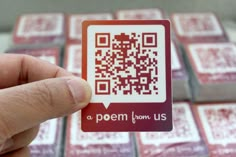 a person holding up a qr - code sticker in front of some red and white squares