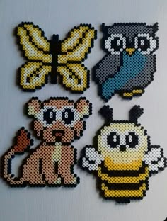 four cross stitch animal magnets on a refrigerator