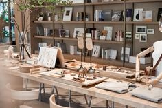 a wooden table topped with mannequins sitting next to bookshelves filled with books