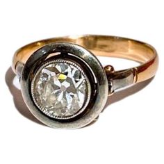 an antique diamond ring is shown in gold and silver with a bezel setting on the side