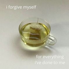 a glass cup filled with green tea on top of a white table