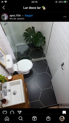 a small bathroom with a toilet, sink and shower stall is seen in this image