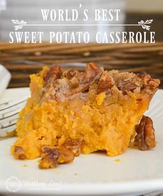 a piece of sweet potato casserole on a white plate with a fork next to it