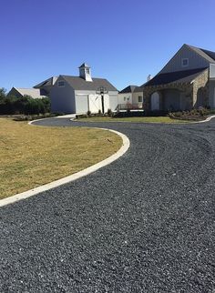 an empty driveway in front of a large house