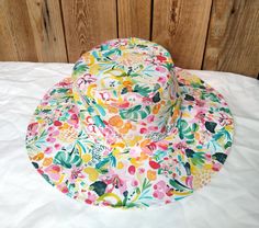 Cotton sun hat made of soft organic cotton. Decorated with a multi-colored floral print, it will fit almost any spring-summer stylization.  Summer hats should be useful, stylish, lightweight and breathable. The hat available in our offer fits perfectly into these aspects, it is an element of clothing that protects the head from the hot rays of the sun. Hat made of airy, certified cotton poplin. The brim of the hat is slightly stiffened, which facilitates modeling. However, this does not prevent Fun Cotton Summer Bucket Hat, Fun Summer Cotton Bucket Hat, Playful Cotton Sun Hat For Spring, Summer Cotton Sun Hat, Cotton Bucket Hat For The Beach, Fun Cotton Summer Hat, Playful Cotton Sun Hat For The Beach, Playful Cotton Sun Hat For Vacation, Fun Cotton Sun Hat For Vacation