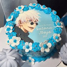 a blue and white birthday cake with an anime character on it