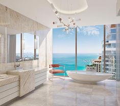 a large bathroom with an ocean view is shown in this image, the bathtub and sink are all white