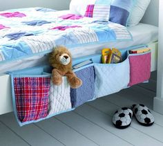 a teddy bear sitting in the pocket of a bed with books and toys on it