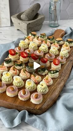 a wooden platter filled with small appetizers