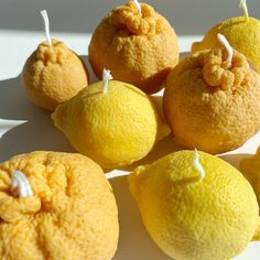 five lemons are arranged on a white surface