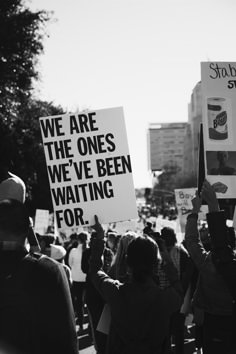 black and white photo of protestors holding placards with words we are the ones we've been waiting for