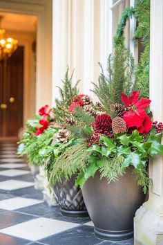 two large pots filled with flowers and greenery on a black and white checkered floor