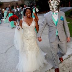 a man and woman are walking down the street with a dog mask on their head