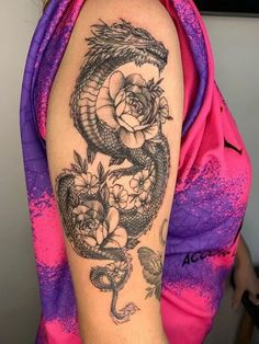 a woman with a dragon and roses tattoo on her arm