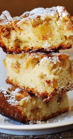 three pieces of cake on a plate with powdered sugar around them and one piece cut in half