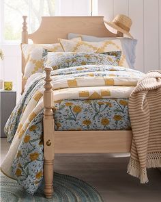 a bed with blue and yellow bedspread in a bedroom