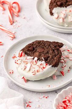 two white plates topped with cookies and candy canes