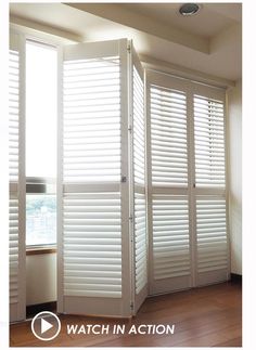 an empty room with white shutters and wood floors