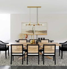 a dining room table and chairs in front of a painting