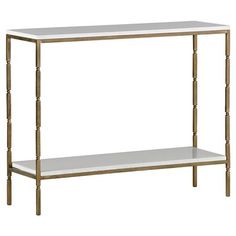 a white and gold console table with two shelves on each side, against a white background