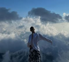 a man standing on top of a mountain with his arms outstretched