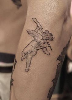 a man with a tattoo on his arm holding a baseball bat in one hand and an arrow in the other