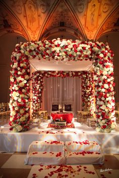 a wedding ceremony setup with red and white flowers