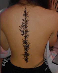 the back of a woman's neck with flowers on her upper and lower back