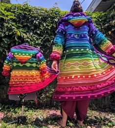 the woman is walking with her child in colorful dresses