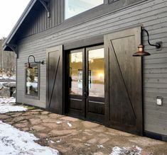 an exterior view of a building with two doors and one light on the outside wall