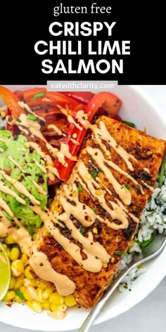 a white bowl filled with grilled fish and vegetables, topped with dressing on the side