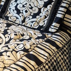 a black and white comforter set on top of a bed with two pillows next to it