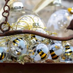 some glass balls are sitting on a branch in front of other christmas ornament