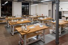 an industrial kitchen with wooden tables and benches