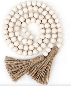 white beads with tassels are arranged on a string and placed next to each other