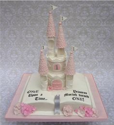 a cake that is shaped like a castle with pink flowers on the bottom and sides