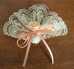 a white lace garter with a pink rose on the top and ribbon around it