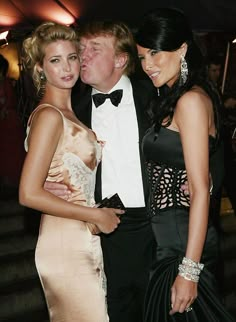 two women and a man standing next to each other in formal wear at an event