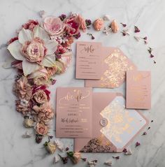 pink and gold wedding stationery with flowers on the side, along with other items