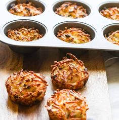 several muffins sitting on top of a wooden table next to a pan filled with them