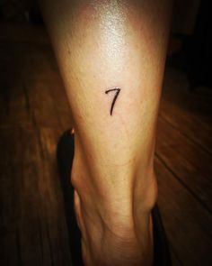 a woman's lower leg with a small tattoo on her left foot and the number seven