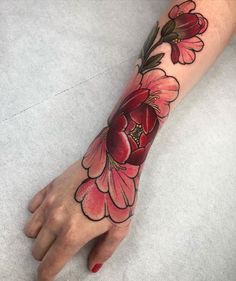 a woman's hand with a flower tattoo on it