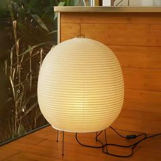 a large white lamp sitting on top of a wooden floor