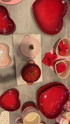 red heart shaped dishes are arranged on a table