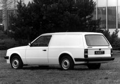 an old white car is parked in the grass