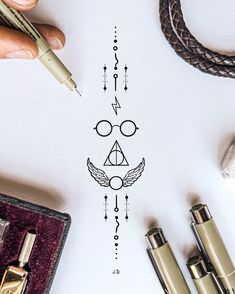 harry potter's symbol drawn on top of a piece of paper next to other items