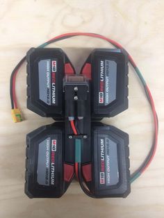 three batteries and wires connected to each other on top of a wooden table with an electronic device